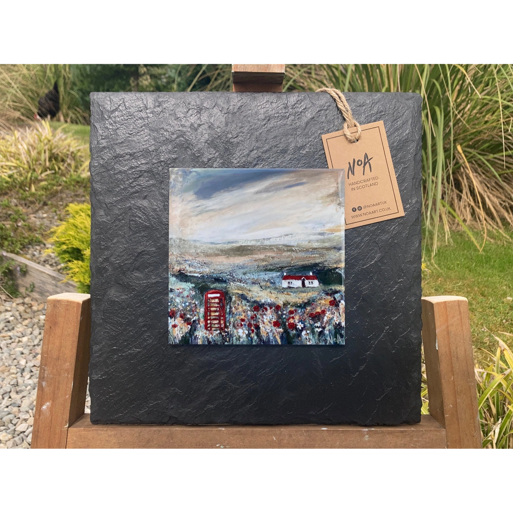 A tile mounted on slate featuring a textured painting of a bothie and telephone box