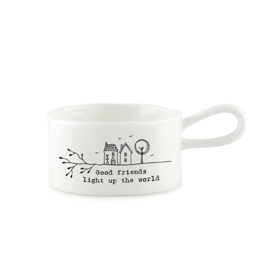 A white handled tealight holder featuring two little houses illustration and a quote