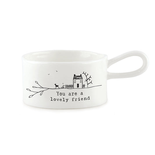 A white handled tealight holder featuring a little house & dog illustration and a quote