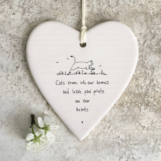 White ceramic heart with a cat illustration and a quote