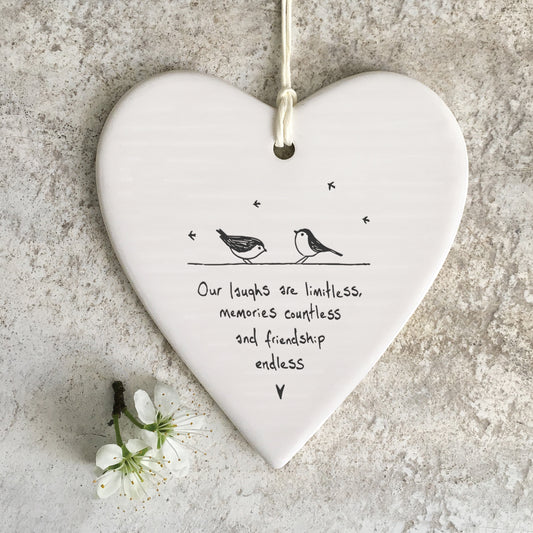 White ceramic heart with a bird illustration and a quote