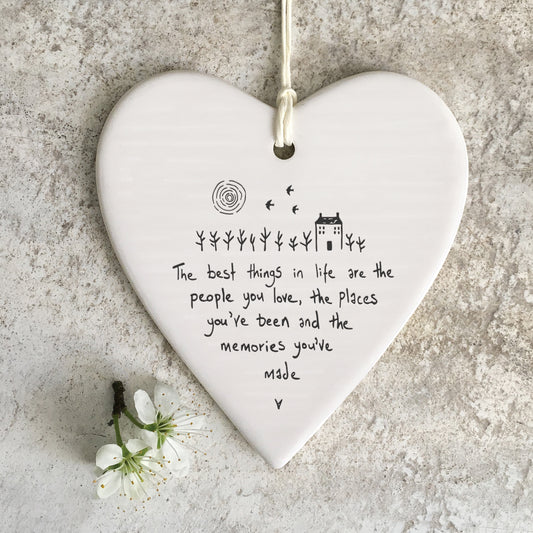 White ceramic heart with a farm house illustration and a quote