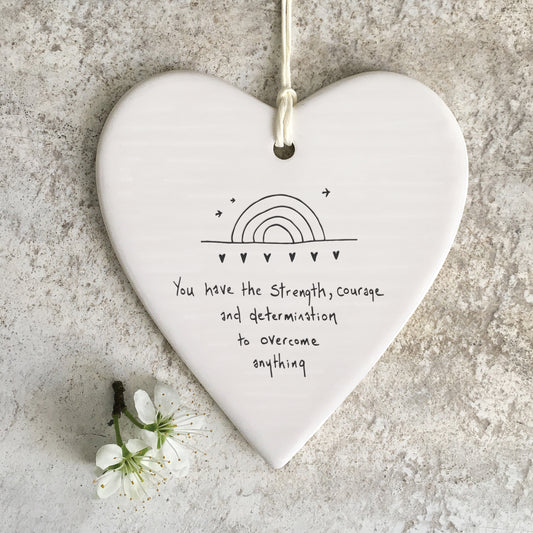 White ceramic heart with a rainbow illustration and a quote