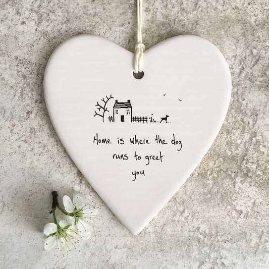White ceramic heart with a house and dog illustration and a quote