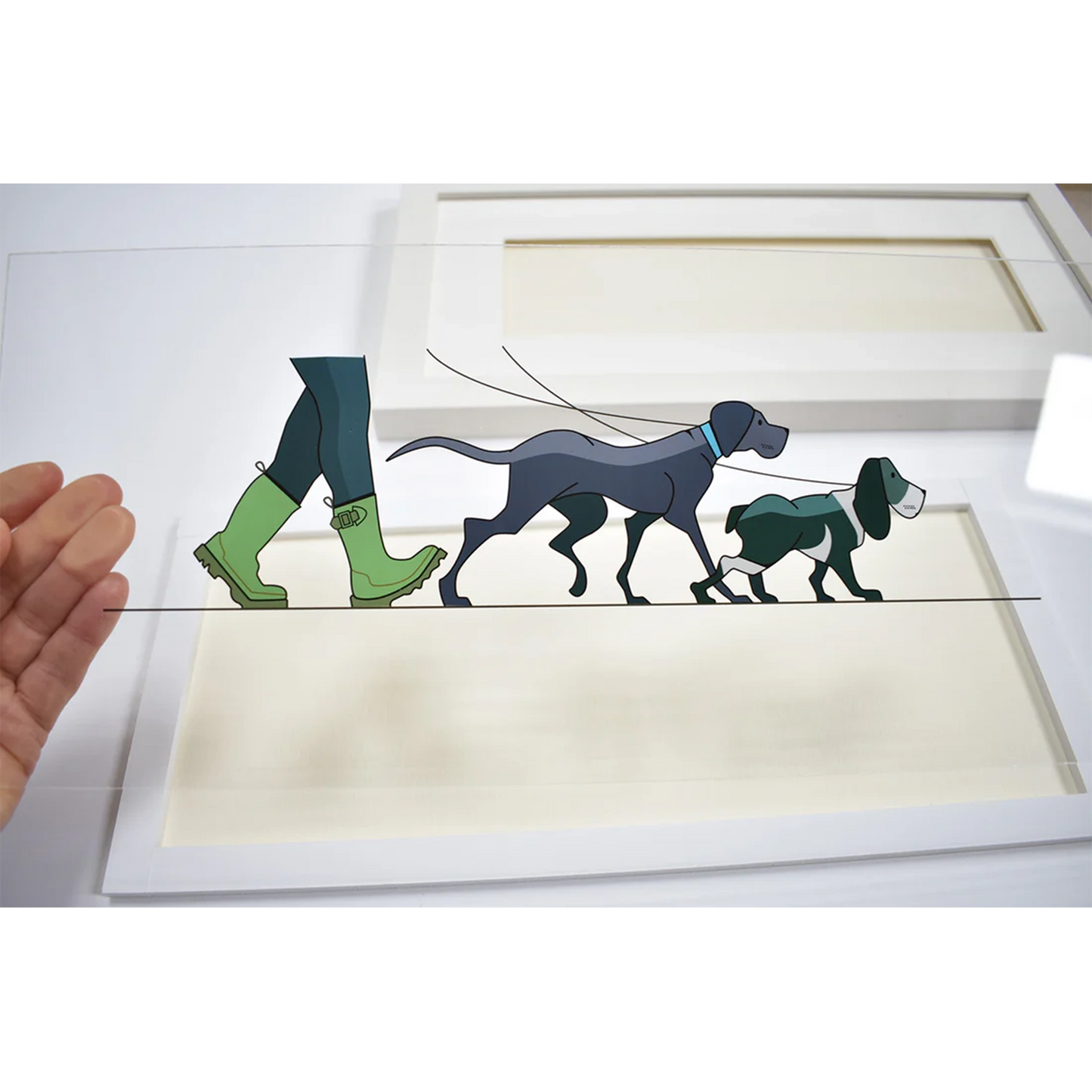 Acrylic art insert featuring a man in green boots walking two dogs