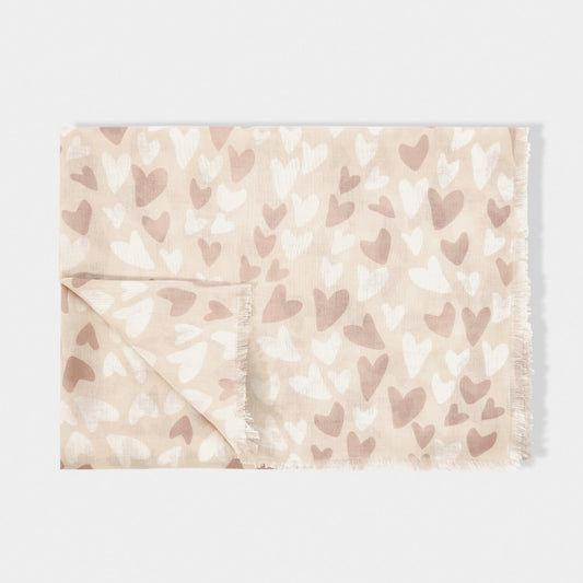 Folded scarf featuring a beige background with white and pink heart pattern and a short fringe