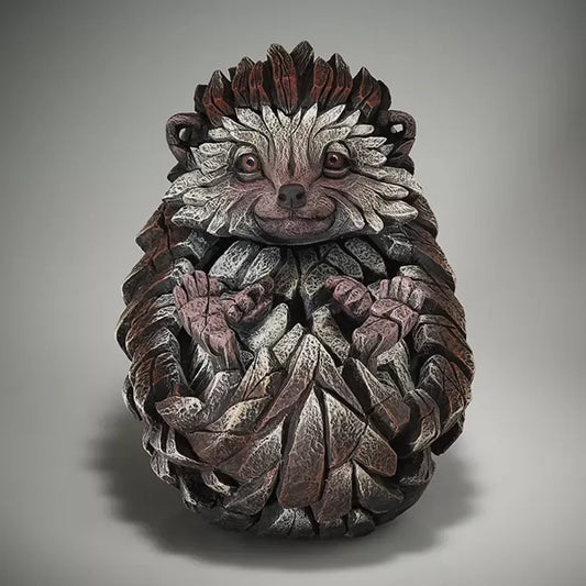 A textured and painted curled sitting hedgehog sculpture