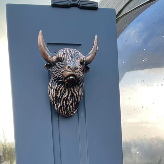 An aged copper coloured Highland cow shaped door knocker