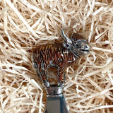 Top of an enamelled Highland cow bottle opener