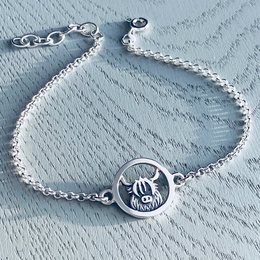 Silver chain bracelet with a pendant featuring a Highland cow in a round frame