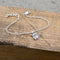 A silver bracelet featuring a chain with a little Highland cow charm