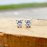 A pair of silver stud earrings shaped like Highland cows