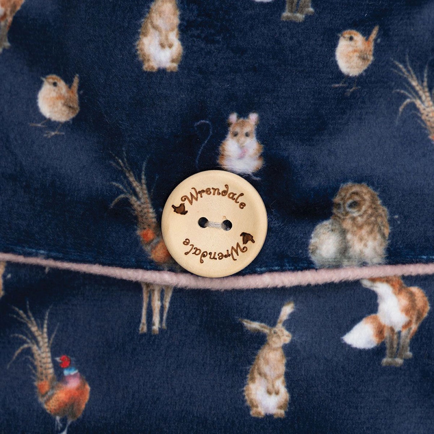 A navy hot water bottle with repeat woodland creature design with wooden button