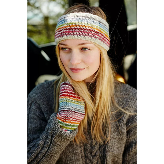 Model wearing a knitted headband with thin rainbow stripes on white