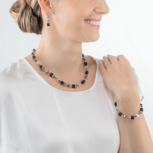 Model wearing a set of jewellery featuring cube shaped stones including onyx and Swarovski crystals