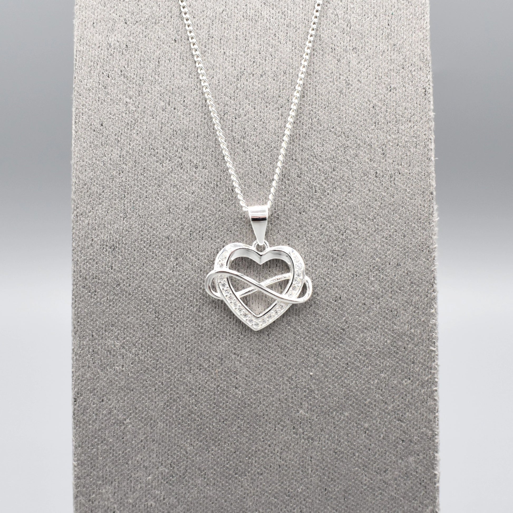 Silver pendant with infinity sign interlocking an open heart set with CZ stones