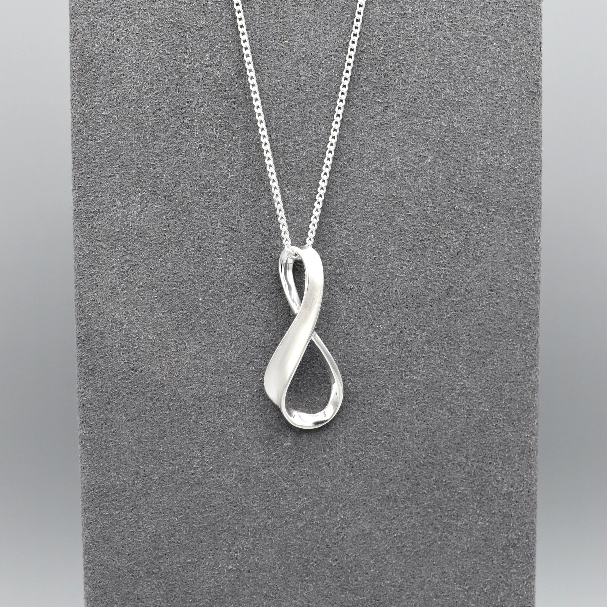 A silver matt & shiny infinity symbol shaped pendant