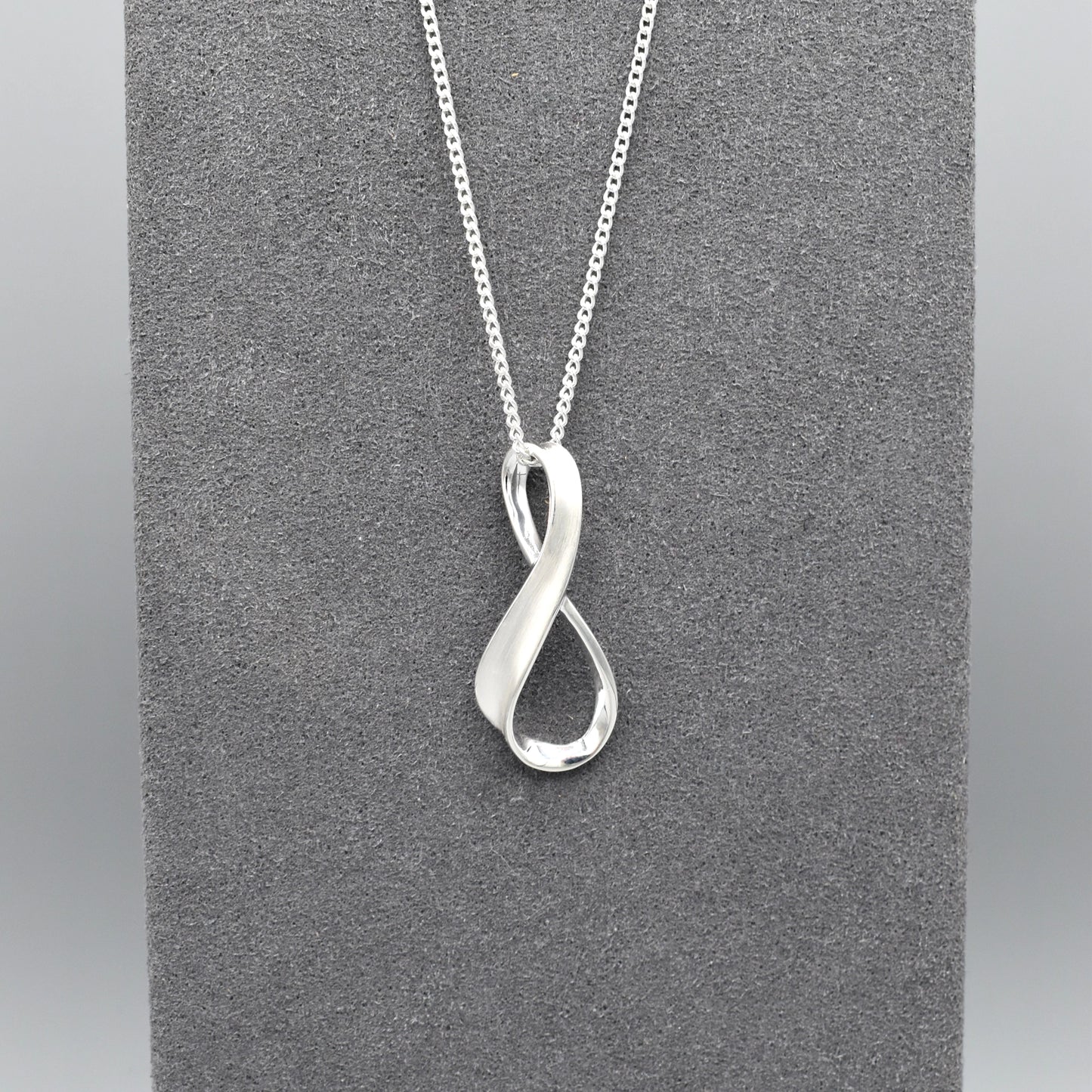 A silver matt & shiny infinity symbol shaped pendant