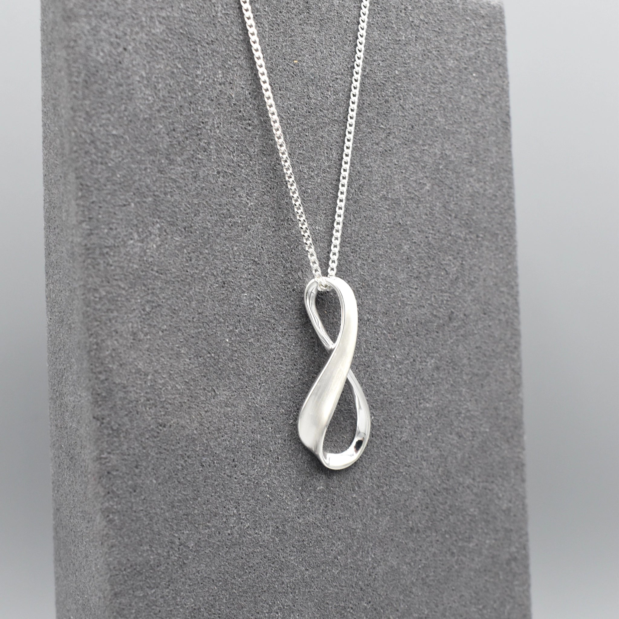 A silver matt & shiny infinity symbol shaped pendant