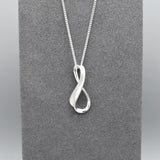 A silver matt & shiny infinity symbol shaped pendant