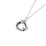 Silver pendant with irregular round shape, a bunny and tree design and a gold heart detail on silver chain