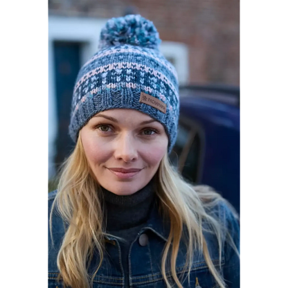 Model wearing a knitted bobble hat with blue and pink stripes
