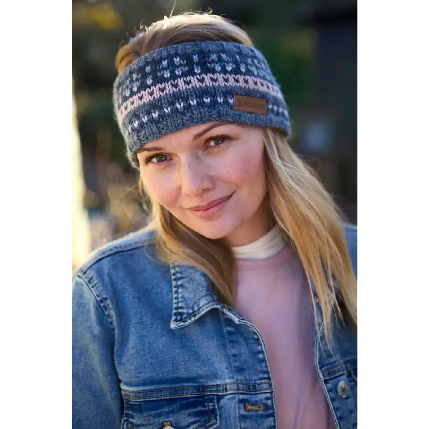 Model wearing a knitted fair isle headband with blue and pink stripes