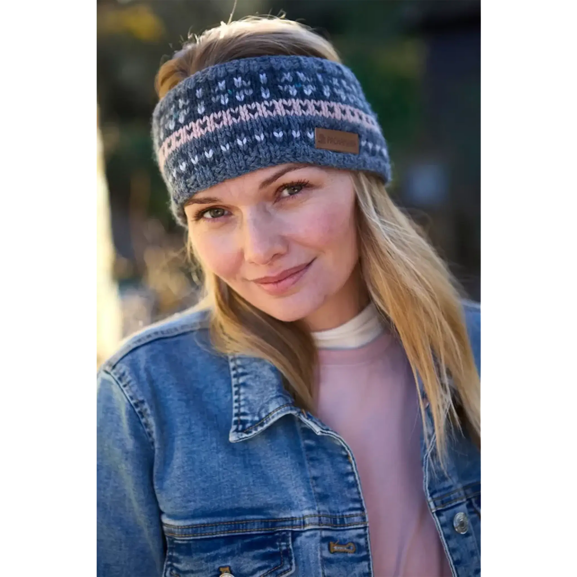Model wearing a knitted fair isle headband with blue and pink stripes