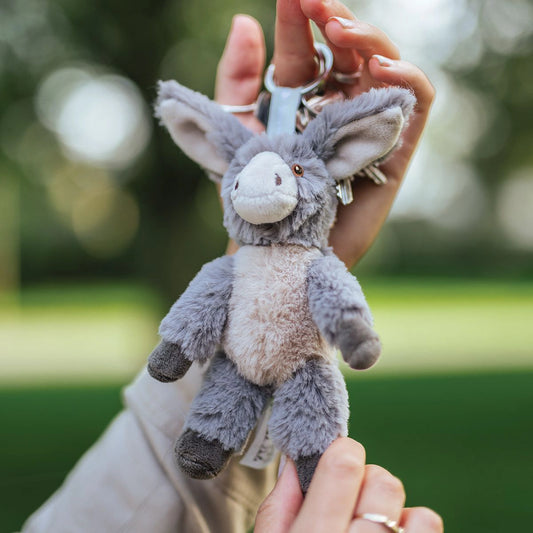 Model holding a plush donkey keychain