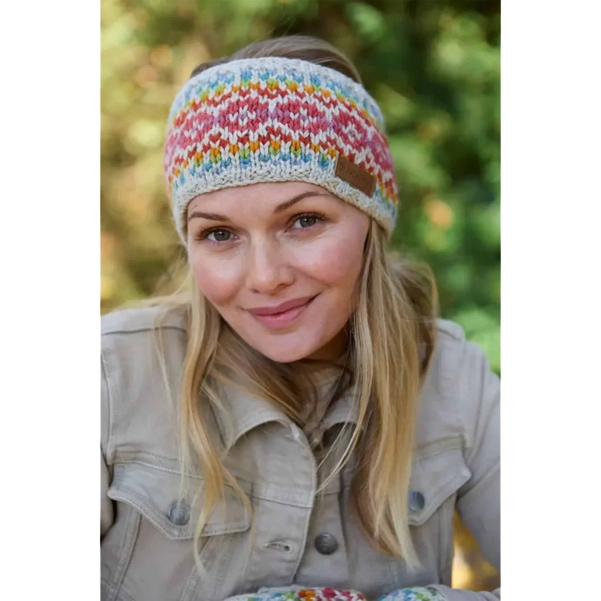 Model wearing knitted oatmeal headband with rainbow chevron heart fair isle pattern