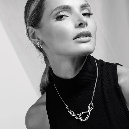 Model wearing a silver double chain necklace with three interlocked infinity symbols
