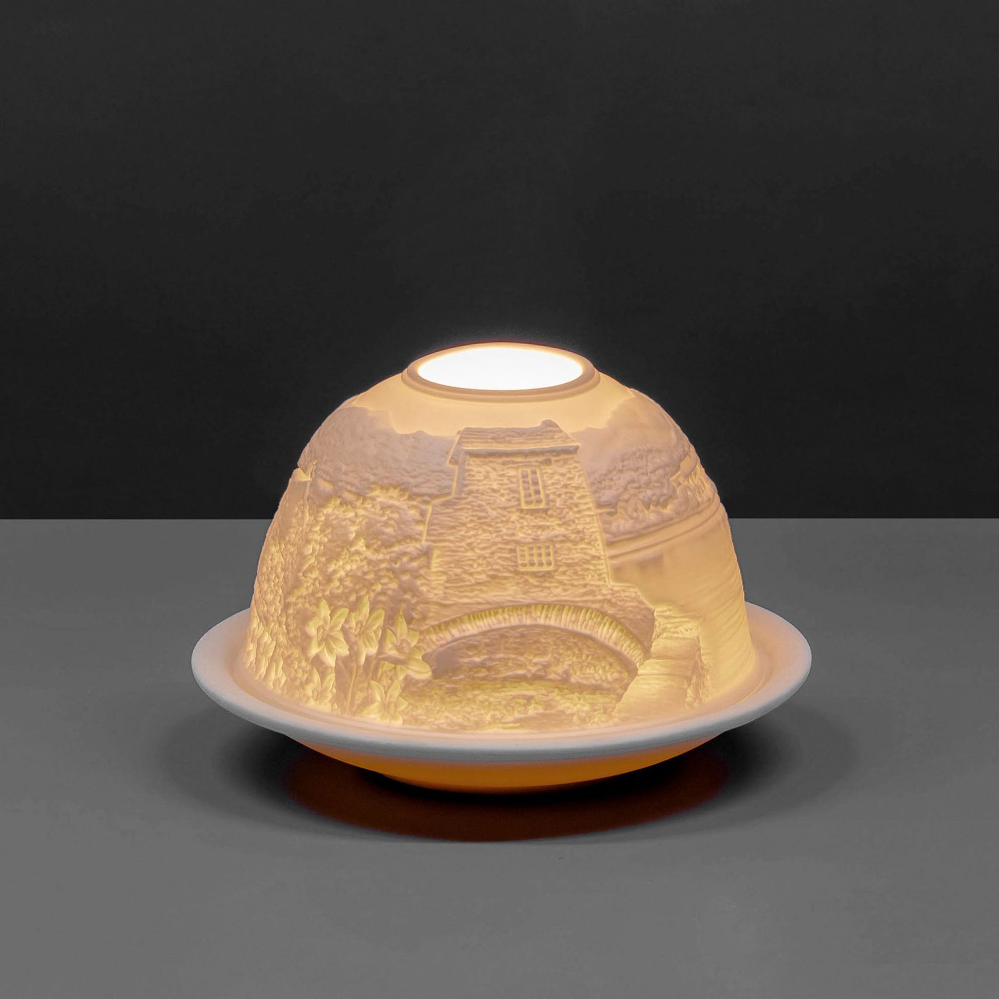 White porcelain tall dome candle holder with engraved Cumbria Lake District scene lit up 2