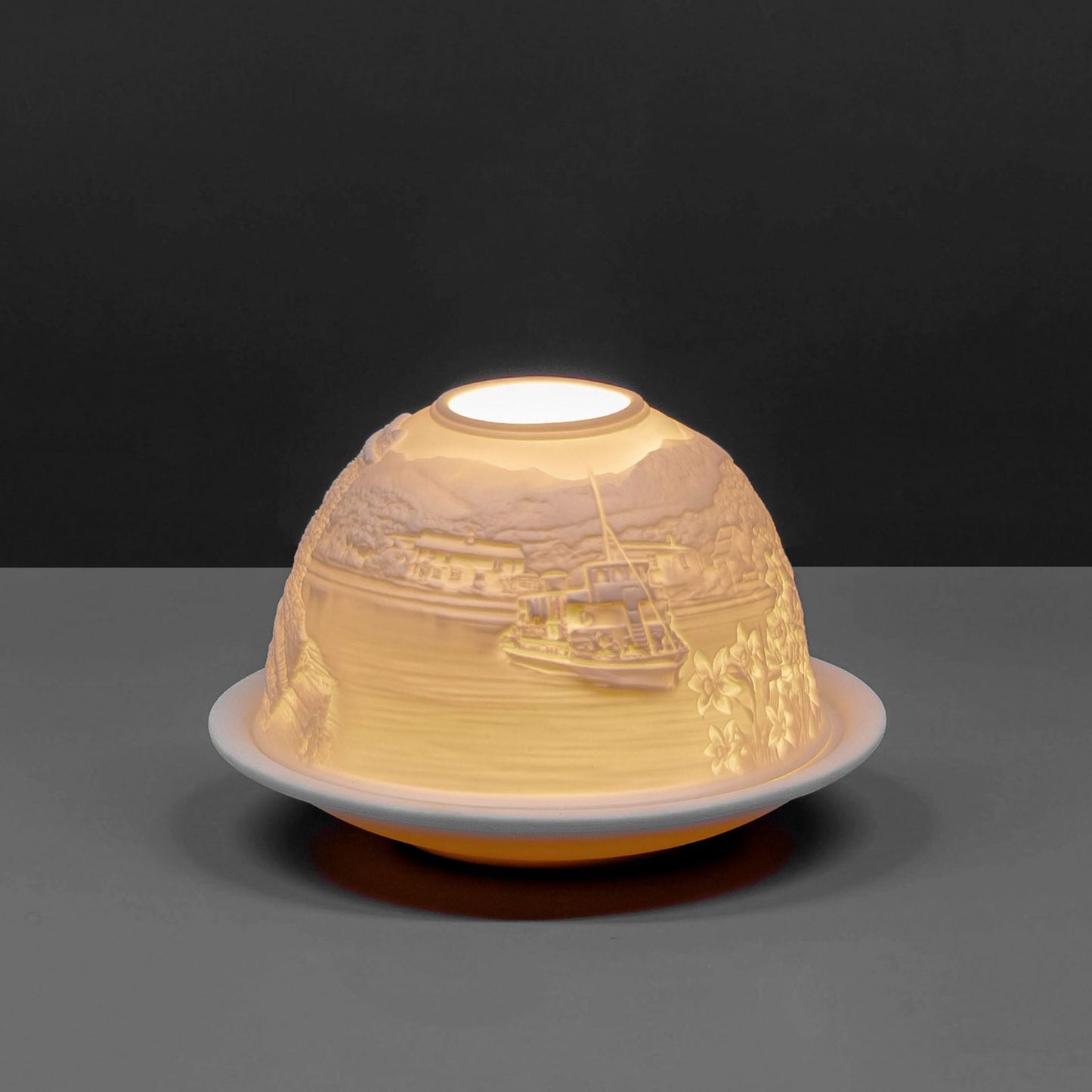 White porcelain tall dome candle holder with engraved Cumbria Lake District scene lit up 