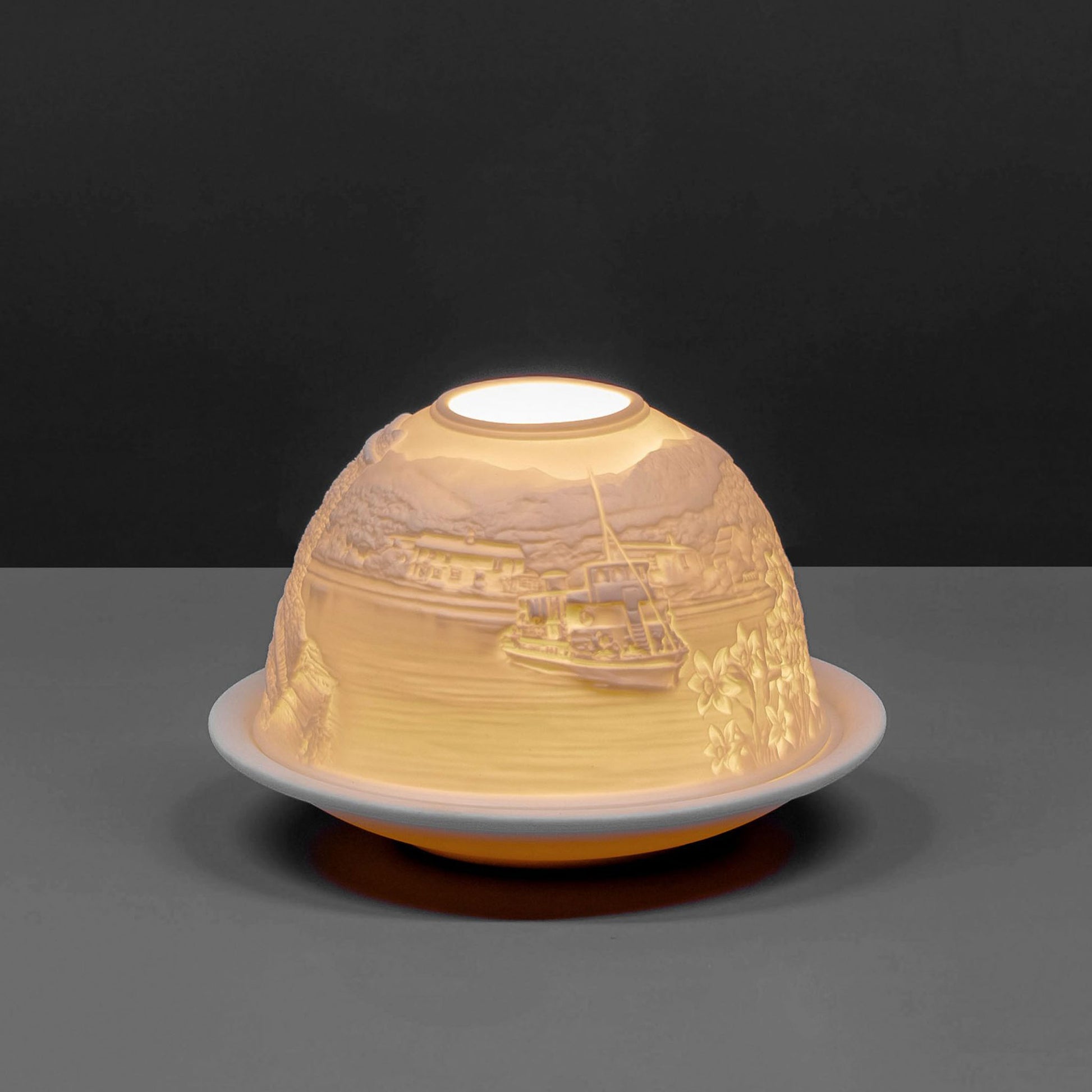 White porcelain tall dome candle holder with engraved Cumbria Lake District scene lit up 