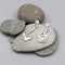 Silver earrings with modern design of a large coiled snake like swirl with polished texture