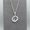 Silver pendant with modern design of a large coiled snake like swirl with polished texture