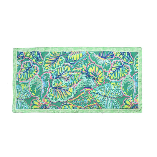 Scarf with a brightly coloured leaf print pattern in pink, blue, yellow and green