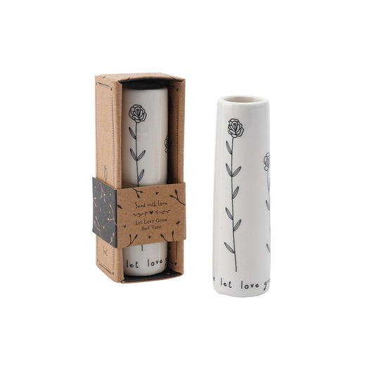 A white ceramic bud vase that says 'Let love grow' with floral pattern