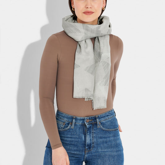 Model wearing a scarf featuring sketch line star pattern in grey and white