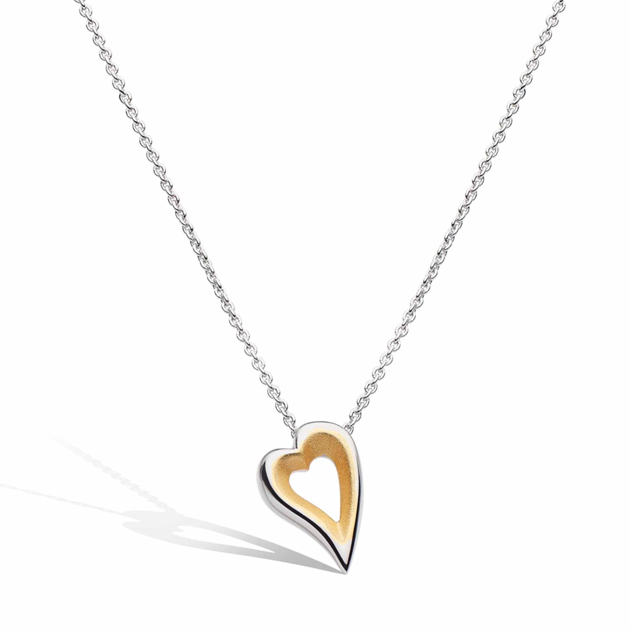 A silver open heart shaped pendant with satin gold plated interior
