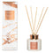 White and rose gold reed diffuser with matching marble patterned box and natural wood reeds