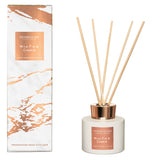 White and rose gold reed diffuser with matching marble patterned box and natural wood reeds