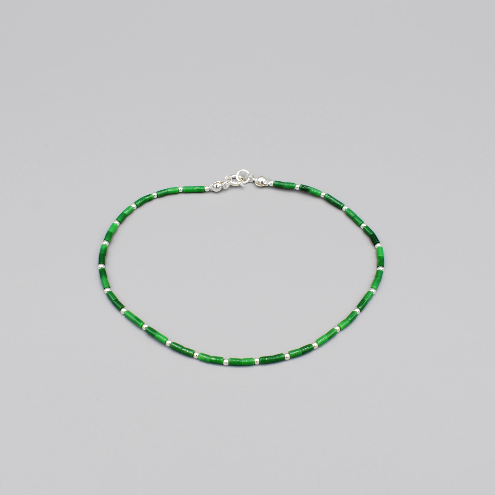 A beaded anklet with cylindrical green malachite and silver ball spacers