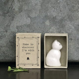 Minimalist white ceramic cat figurine in a box with a quote