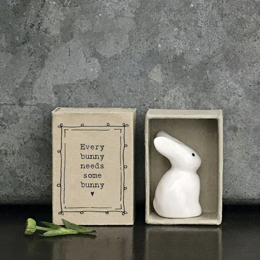 Minimalist white ceramic bunny figurine in a box with a quote