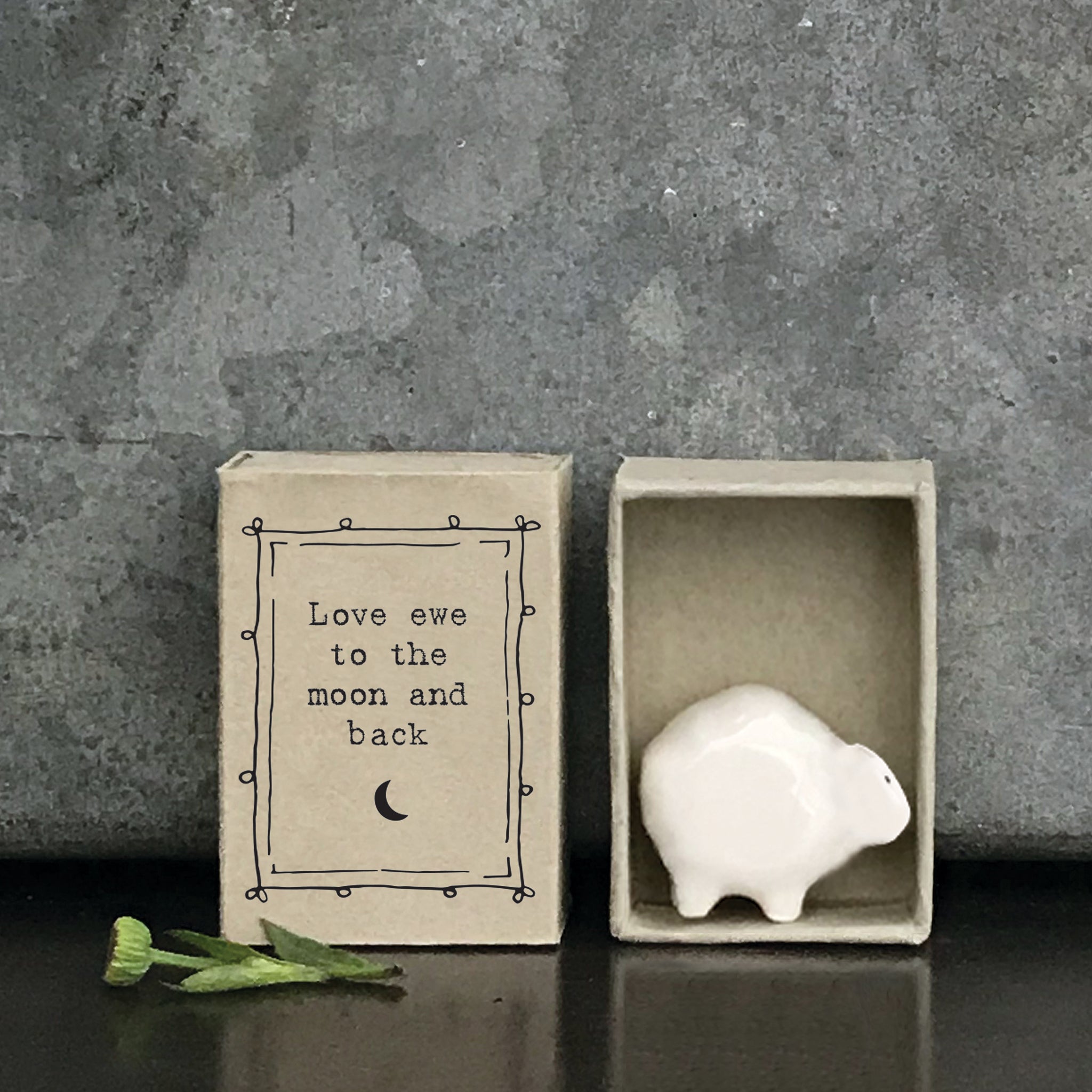 Minimalist white ceramic sheep figurine in a box with a quote