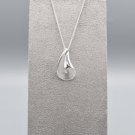 A curved pendant with a twist in a matt and polished silver finish on a silver chain