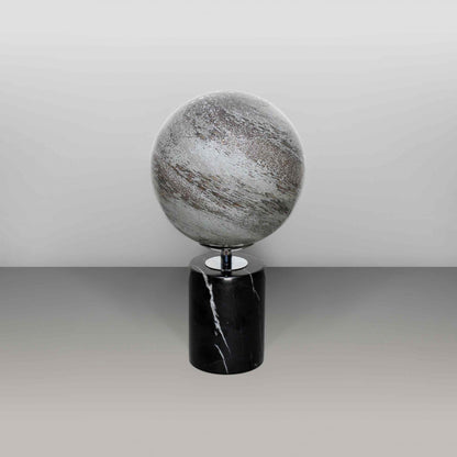 Round glass globe light based on the planet Mercury and set on a black marble base off