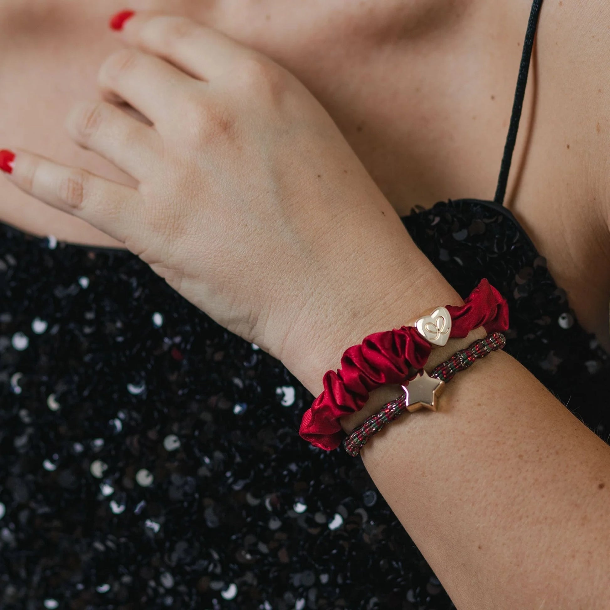 Model wearing a metallic tri coloured bubble shaped hair tie with gold star charm as a bangle