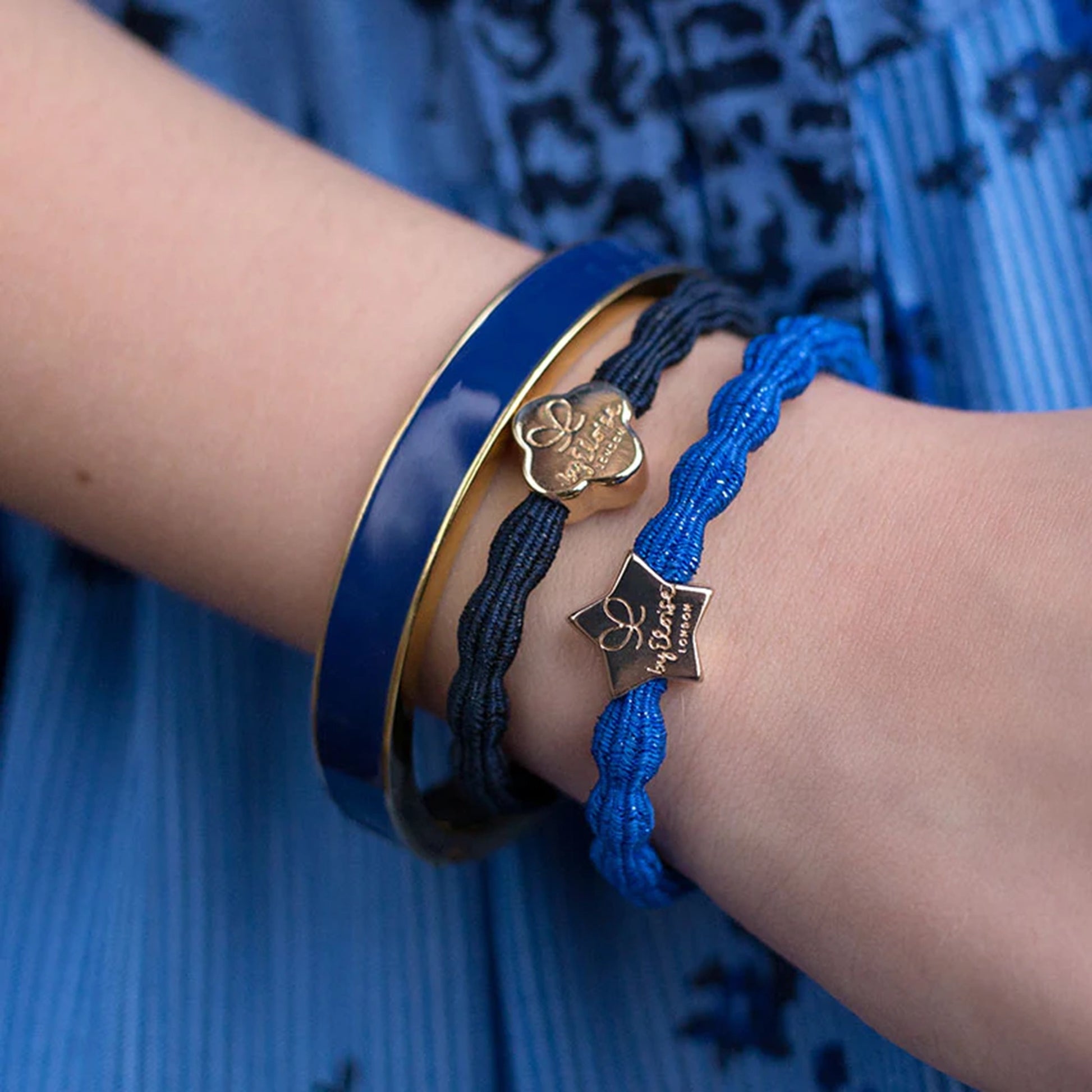 Model wearing metallic royal blue coloured bubble shaped hair tie with gold star charm